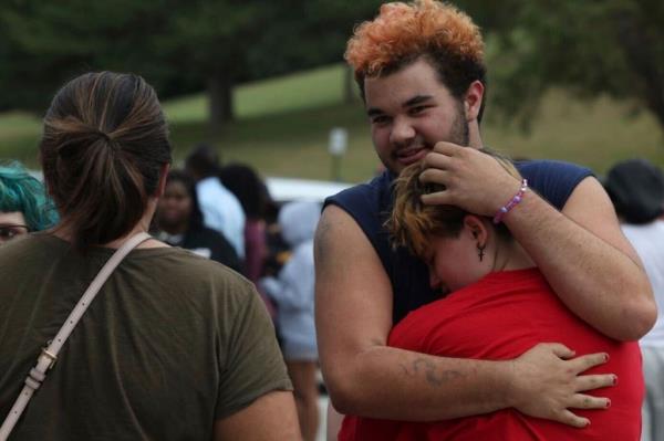Artemis Else, right, hugs Angie Caswell as they wait outside Northwest high school after a shooting was reported Tuesday,